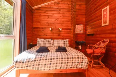 a bedroom with a bed in a log cabin at 18 Lamont Lodges in Dunoon