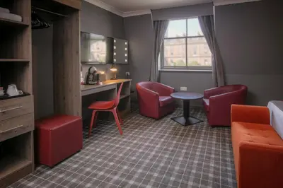 a room with red chairs and a table and a desk at Best Western Glasgow Hotel in Glasgow