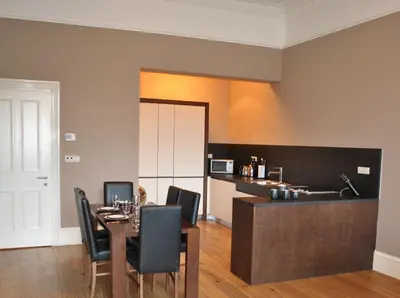 a dining room with a table and black chairs at Dreamhouse Apartments Glasgow West End in Glasgow