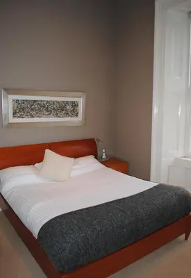 a bedroom with a large bed with white sheets and a window at Dreamhouse Apartments Glasgow West End in Glasgow