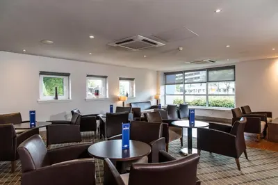 a waiting room with tables and chairs at Holiday Inn Express - Glasgow Airport by IHG in Paisley