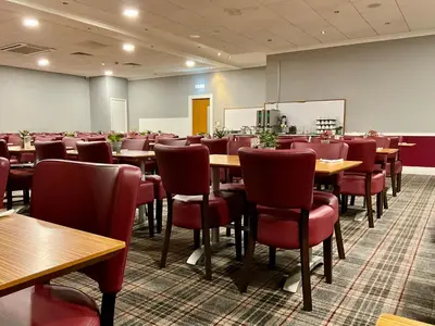 a dining room with tables and red chairs at Britannia Edinburgh Hotel in Edinburgh
