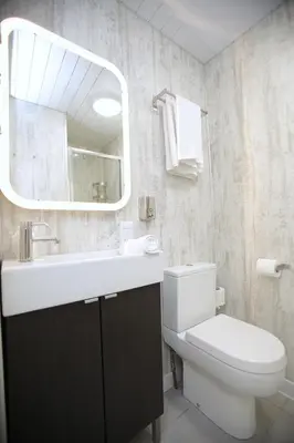 a bathroom with a toilet and a sink and a mirror at Ambassador Hotel in Glasgow