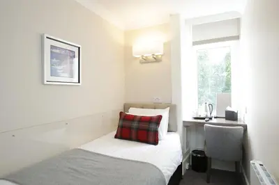 a small room with a bed and a desk at Ambassador Hotel in Glasgow