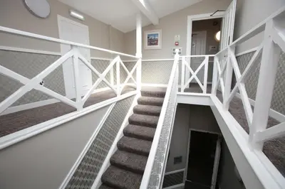 a staircase in a house with white railings at Ambassador Hotel in Glasgow