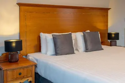 a bedroom with two beds and a wooden headboard at Glasgow Argyle Hotel, BW Signature Collection in Glasgow