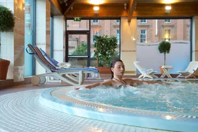 a woman in a hot tub in a hotel room at Glasgow Argyle Hotel, BW Signature Collection in Glasgow