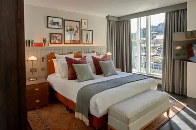 a bedroom with a large bed and a large window at Kimpton Charlotte Square by IHG in Edinburgh