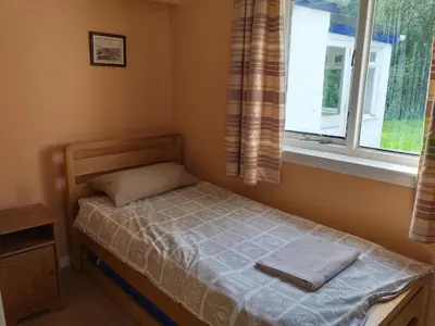 a small bed in a room with a window at Craignavie Cottage in Killin