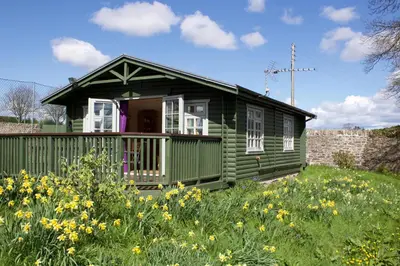 a green house in a field of flowers at Garden Studio for Two in Doune
