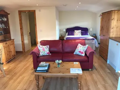 a living room with a couch and a bed at Garden Studio for Two in Doune