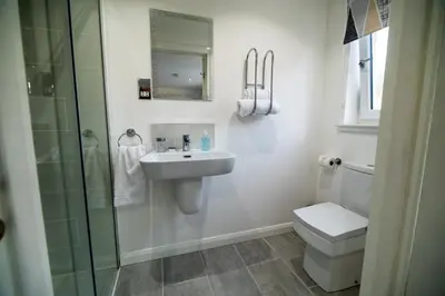 a bathroom with a sink and a toilet and a shower at Alma Villa in Falkirk
