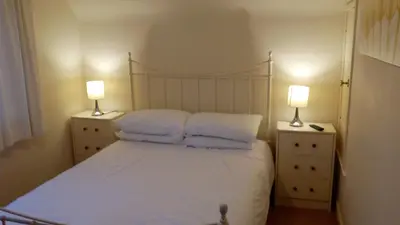 a bedroom with a bed with pillows and two lamps at Feochan View in Oban