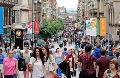 a crowd of people walking down a busy city street at Glasgow City Centre Flat with River Views and Parking in Glasgow
