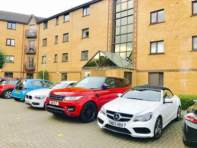 a row of cars parked in front of a building at Glasgow City Centre Flat with River Views and Parking in Glasgow