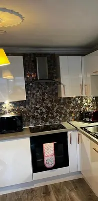 a kitchen with white cabinets and a black dishwasher at Glasgow City Centre Flat with River Views and Parking in Glasgow