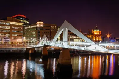 a bridge over a river in a city at night at Glasgow City Centre Flat with River Views and Parking in Glasgow