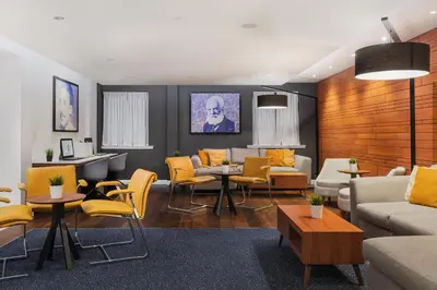 a living room with yellow chairs and a couch at Courtyard by Marriott Glasgow Airport in Paisley