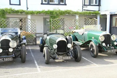 three old cars parked in a parking lot at Annandale Arms Hotel in Moffat