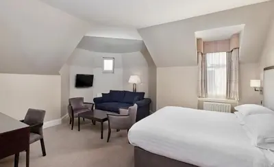 a bedroom with a bed and a desk and a couch at Leonardo Edinburgh City in Edinburgh