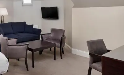 a living room with a couch and a table and chairs at Leonardo Edinburgh City in Edinburgh