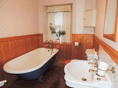 a bathroom with a tub and a toilet and a sink at Springburn Cottage in Strachur