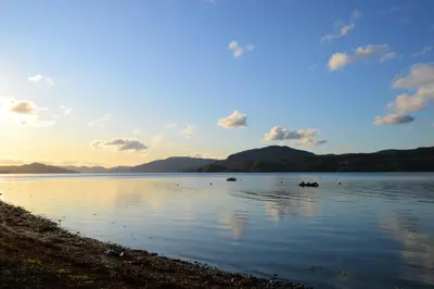 a body of water with mountains in the background at Springburn Cottage in Strachur
