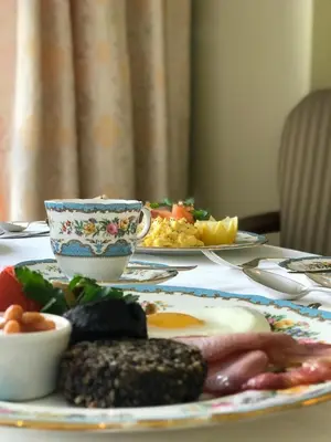 a table with a plate of food and a cup of coffee at Glenegedale House in Kintra