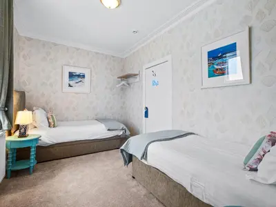 a bedroom with two beds and a table with a lamp at No. 1 Charlotte Street in Port Ellen
