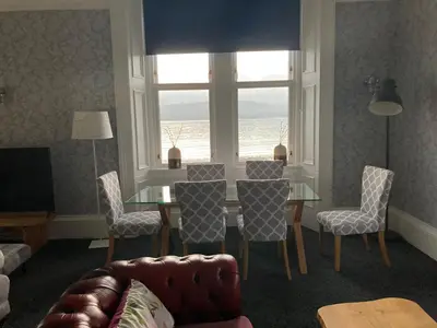 a living room with a table and chairs and a window at No. 1 Charlotte Street in Port Ellen