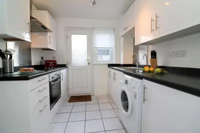 a kitchen with white cabinets and a dishwasher at Signature - Atholl House Glasgow Airport in Paisley