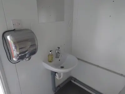a white bathroom with a sink and a mirror at MacDonald Cabins in Kinlochleven