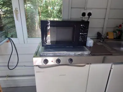 a microwave sitting on top of a counter in a kitchen at MacDonald Cabins in Kinlochleven