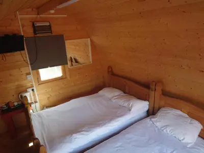 a bedroom with two beds in a log cabin at MacDonald Cabins in Kinlochleven