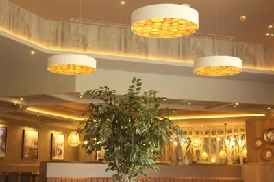a dining room with two lights and a plant at Riverside Lodge Hotel in Irvine