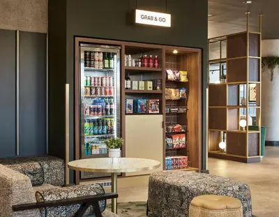 a coffee shop with a table and a drinkacistacistacistacistacistacist at Leonardo Royal Hotel Glasgow in Glasgow