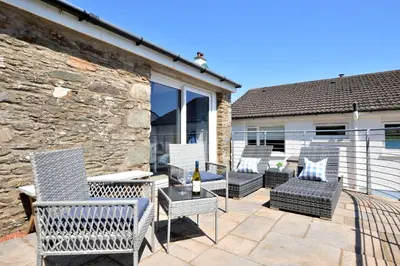 a patio with chairs and a table with a bottle of wine at Craignethan in Kames