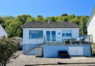 a small blue house with a balcony and a staircase at Craignethan in Kames