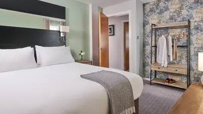 a bedroom with a large white bed and a closet at Fraser Suites Glasgow in Glasgow