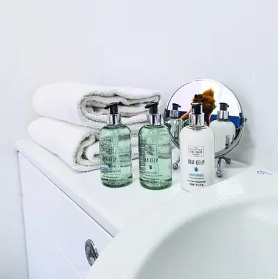 a bathroom with four bottles of soap and a mirror at Ben Cruachan Inn - Restaurant, Pub with Rooms in Loch Awe