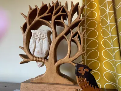 a wooden sculpture of an owl in a tree at Creity Hall Chalet in Stirling