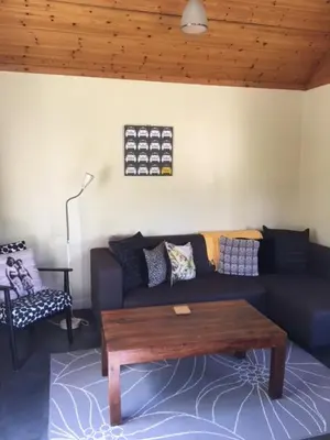 a living room with a blue couch and a coffee table at Creity Hall Chalet in Stirling