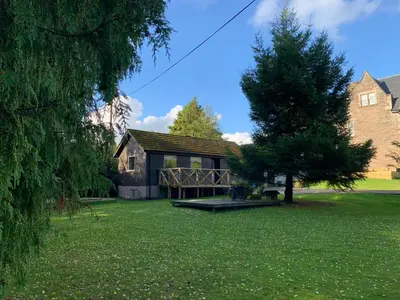 a house with a picnic table in a yard at Creity Hall Chalet in Stirling