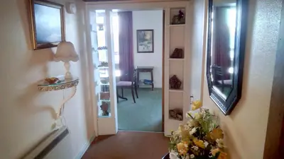 a hallway with a room with a mirror and a vase of flowers at bayviewapartment in Oban