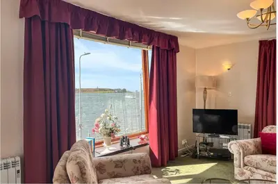 a living room with a large window with a view of the water at bayviewapartment in Oban