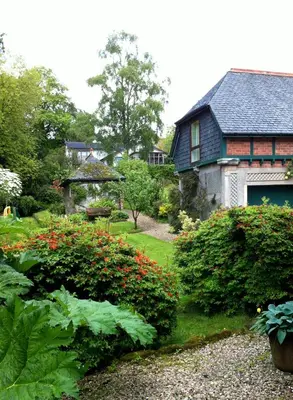a garden in front of a house with a garage at Coach House at The Glen in Helensburgh