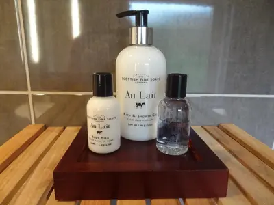 a couple of bottles of soap on a wooden shelf at Coach House at The Glen in Helensburgh