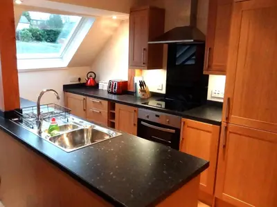 a kitchen with a sink and a stove at Coach House at The Glen in Helensburgh