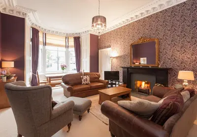 a living room with a couch and a fireplace at The Coates Gardens Residence in Edinburgh