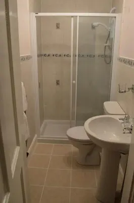 a bathroom with a shower and a toilet and a sink at Briar Brae Bed & Breakfast in Stranraer
